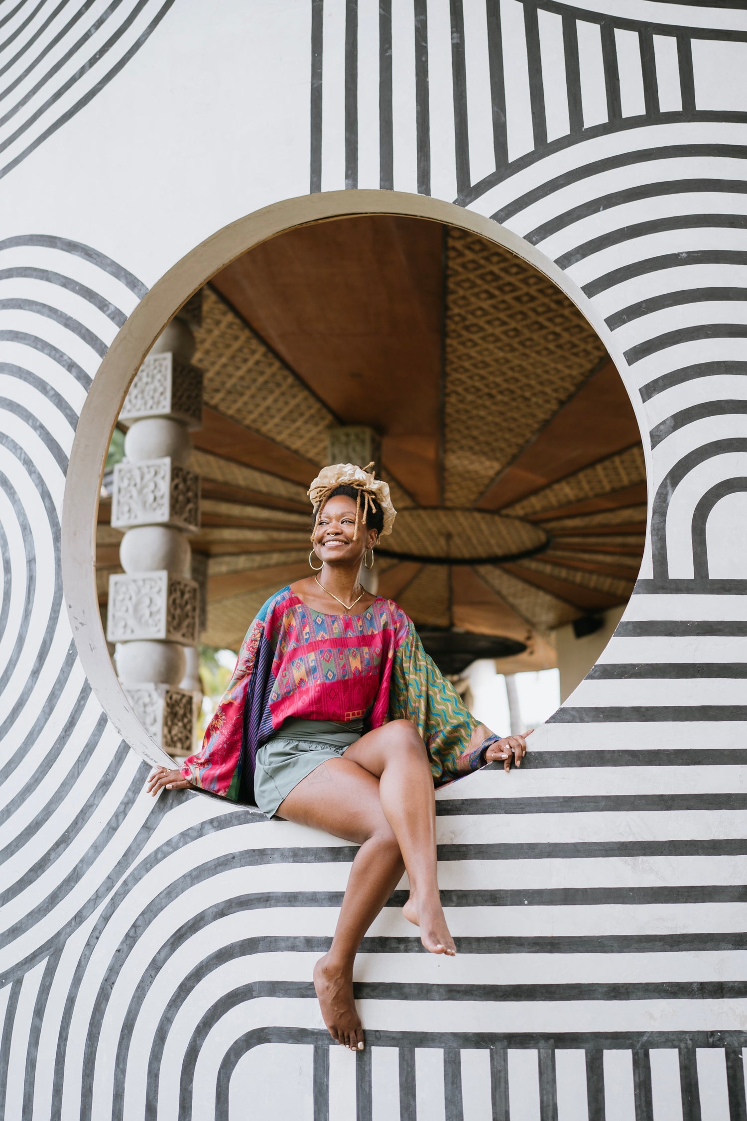 Founder sitting inside a circular architectural feature with striped walls.