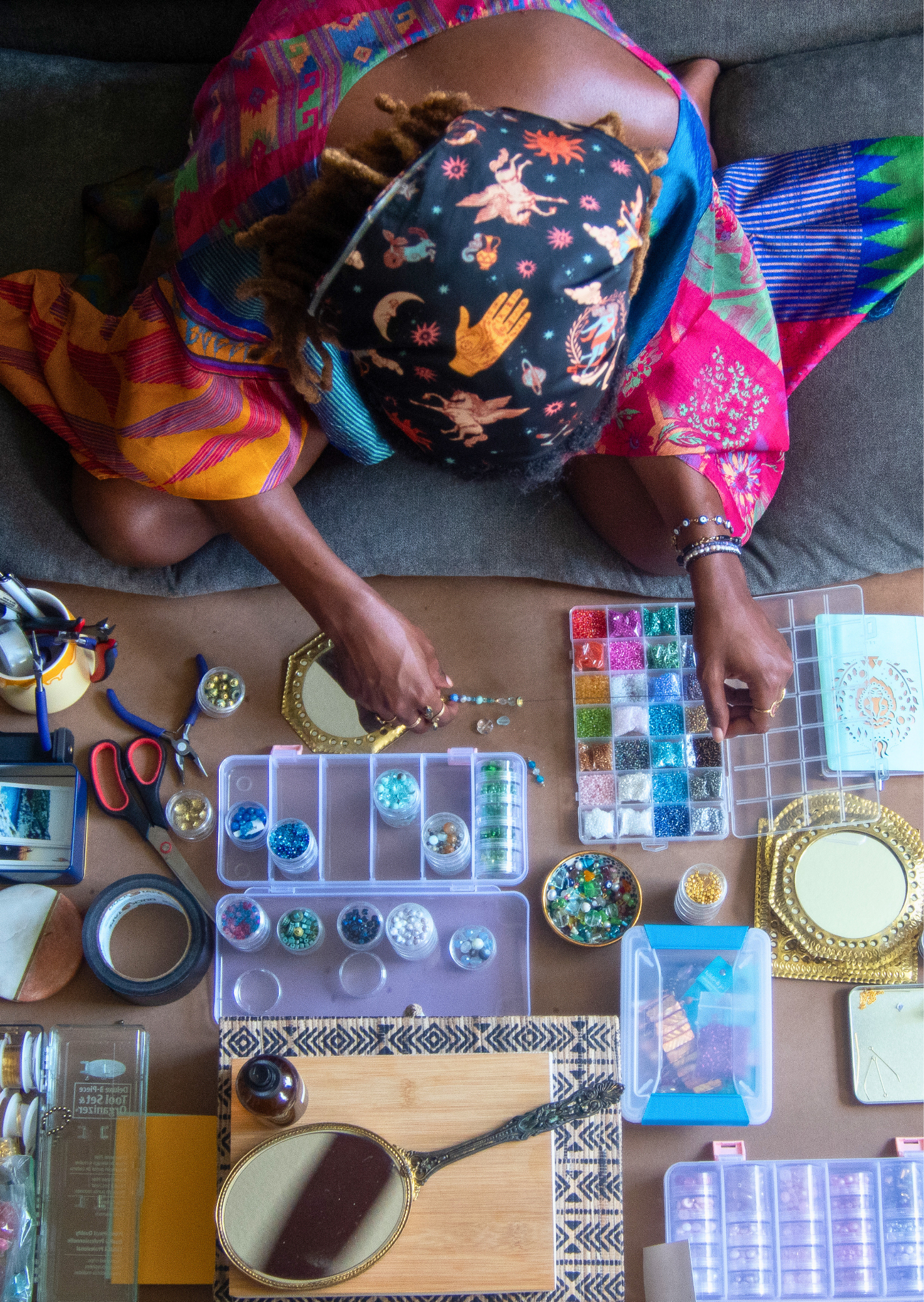 Person sitting on a couch with art supplies on a table in front of them