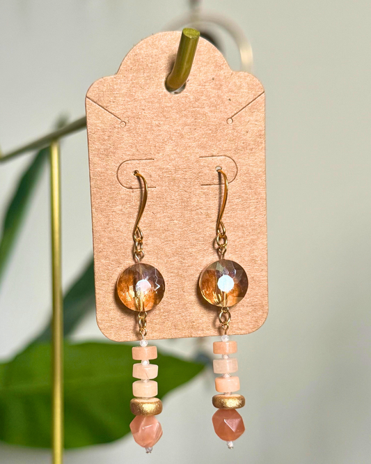 Pair of earrings on a cardstock earring card against a blurred natural background